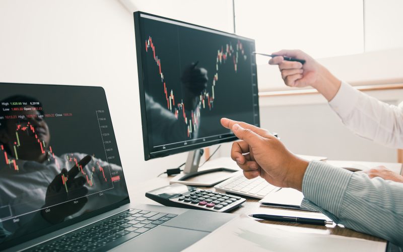 Two business stock brokers stress and looking at monitors displaying financial